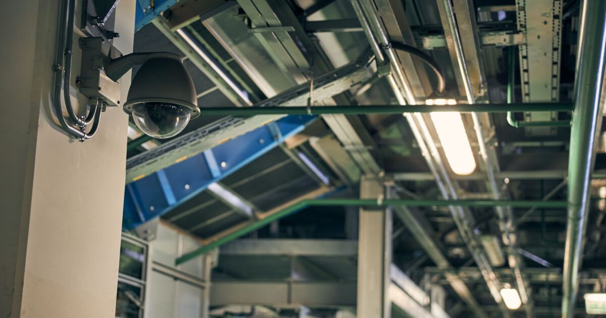 Security surveillance camera on a wall of a building