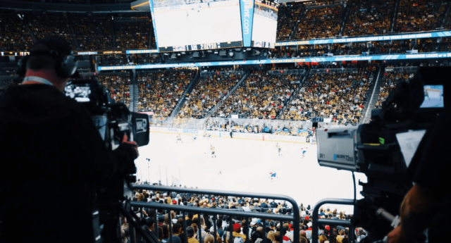 Camera man films an NHL hockey game.
