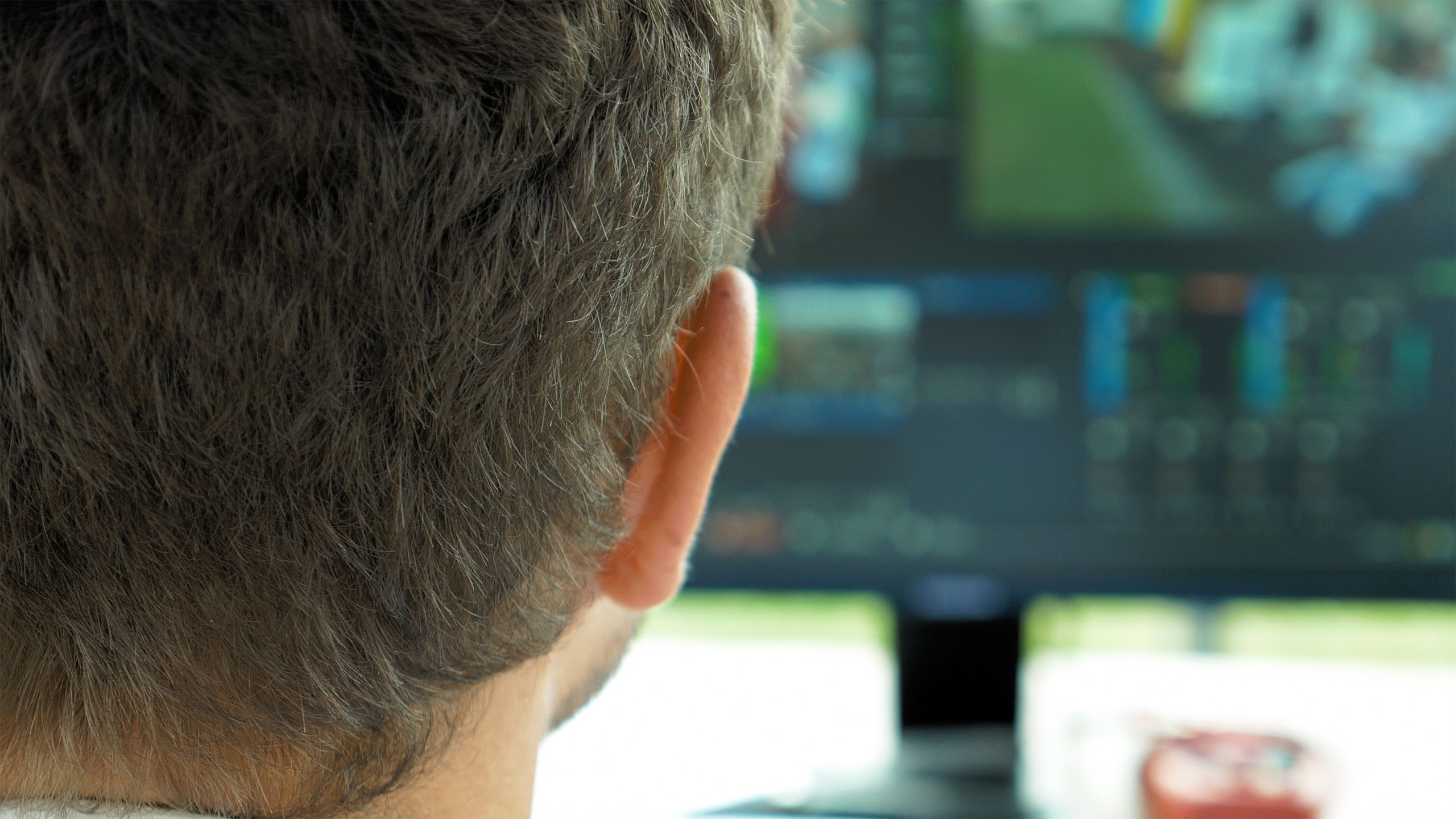 Video broadcast editor with headphones at screen