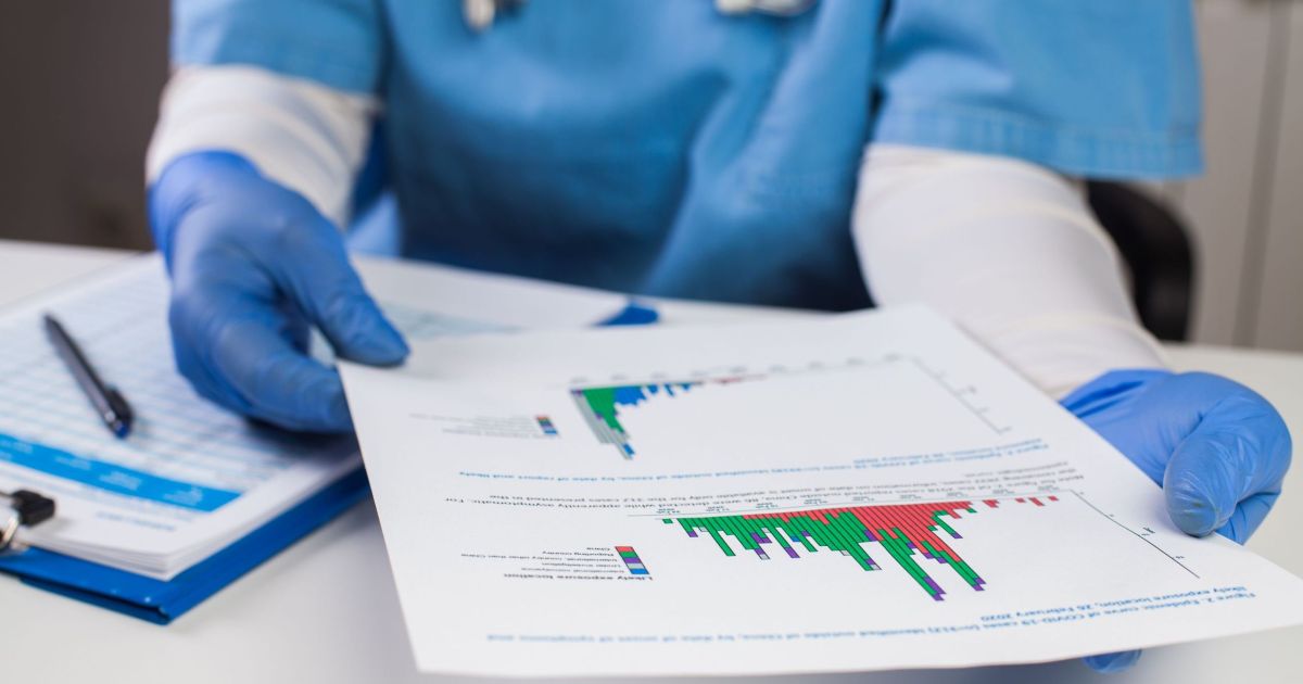 Doctor wearing gloves looking over patient data
