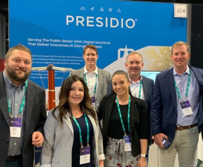 colleagues posing at Presidio booth
